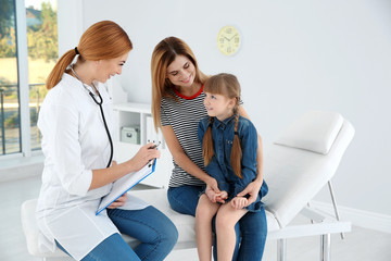 Wall Mural - Mother and daughter visiting pediatrician. Doctor working with patient in hospital