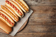 Tasty fresh hot dogs on wooden table, top view. Space for text