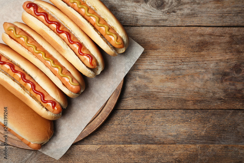 Fototapeta na szkło Smakowici świezi hot dog na drewnianym stole, odgórny widok. Miejsce na tekst