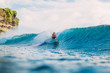 Surf girl on surfboard. Wipeout of surfer woman from surfboard on blue wave