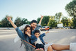 © teksomolika - Young dad carries mom and son in a cart on the parking lot