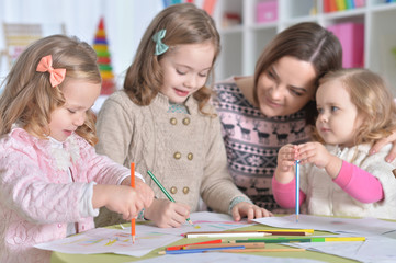 portrait of mother and her three daughters drawing together