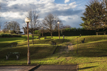 Green park in autumn with banks and clouds