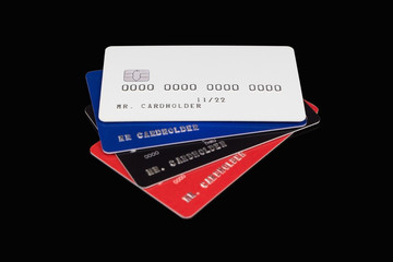 Wall Mural - Stack of multicolored credit cards on black background, white card on top