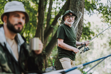 Joyful elderly man enjoying fishing on the weekend