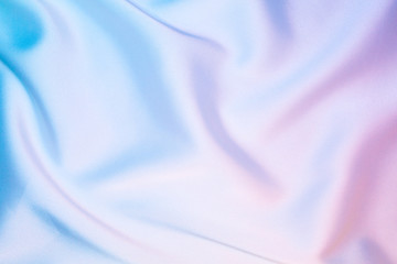 Silk shiny fabric texture in pastel iridescent holographic colors