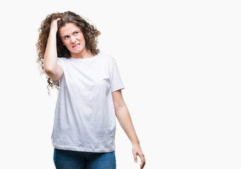 Beautiful brunette curly hair young girl wearing casual t-shirt over isolated background confuse and wonder about question. Uncertain with doubt, thinking with hand on head. Pensive concept.