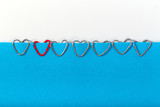 Fototapeta Dziecięca - Clips in the form of hearts on a blue sheet of paper