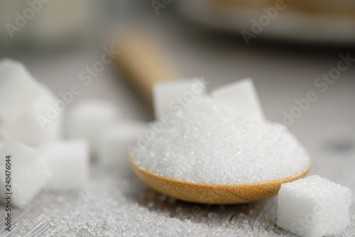 Fotografie, Obraz Sugar in wooden spoon for putting in coffee, adding sweetness - image