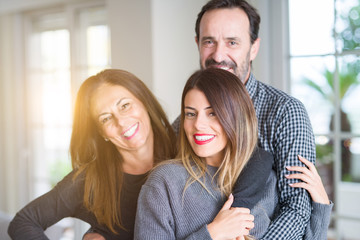 Beautiful family together. Mother, father and daughter smiling and hugging with love at home.