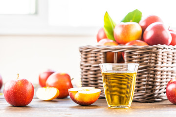 Wall Mural - Apples juice in glass with apple in the basket