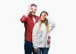 © Krakenimages.com - Young couple in love wearing winter sweater over isolated background doing ok gesture with hand smiling, eye looking through fingers with happy face.