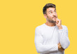 © Krakenimages.com - Young handsome man over isolated background with hand on chin thinking about question, pensive expression. Smiling with thoughtful face. Doubt concept.