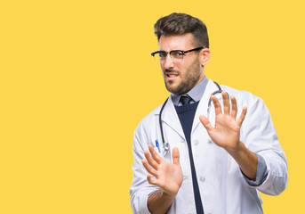 Canvas Print - Young handsome doctor man over isolated background disgusted expression, displeased and fearful doing disgust face because aversion reaction. With hands raised. Annoying concept.