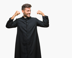 Young catholic christian priest man over isolated background showing arms muscles smiling proud. Fitness concept.