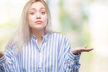 Sticker - Young blonde woman over isolated background clueless and confused expression with arms and hands raised. Doubt concept.