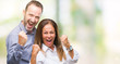 © Krakenimages.com - Middle age hispanic business couple over isolated background very happy and excited doing winner gesture with arms raised, smiling and screaming for success. Celebration concept.