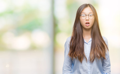 Poster - Young asian business woman wearing glasses over isolated background afraid and shocked with surprise expression, fear and excited face.