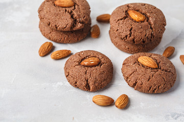 Chocolate cookies with almonds on white background, copy space. Vegan dessert concept.