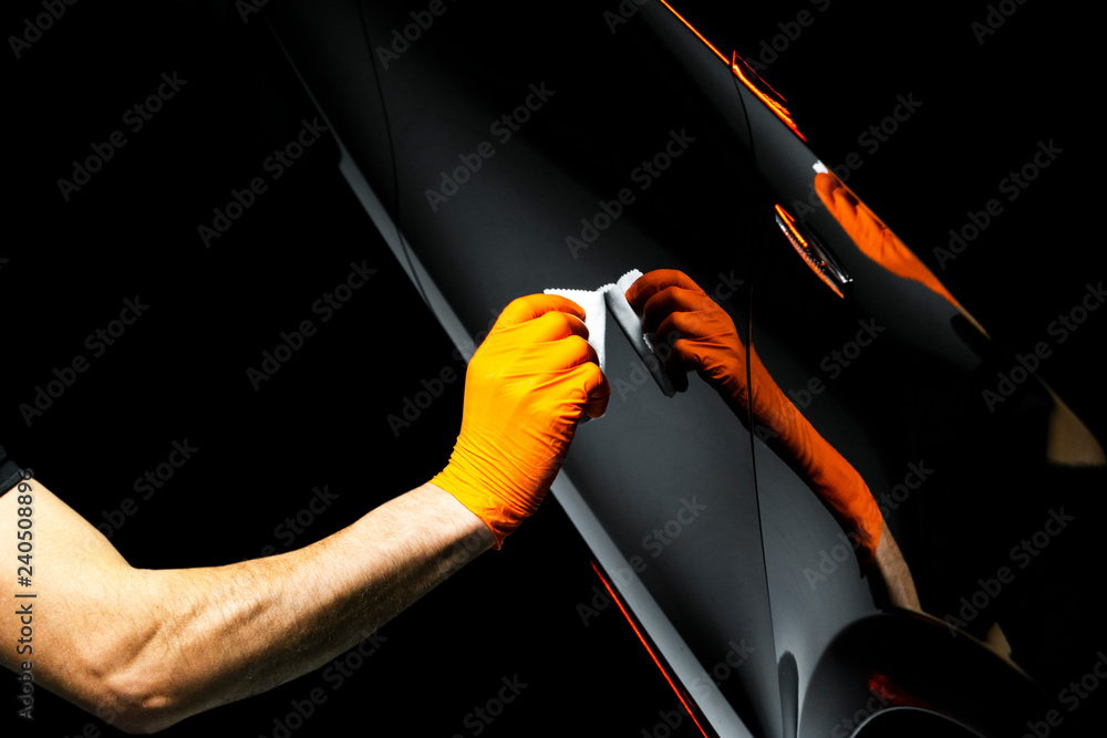 Car polish wax worker hands polishing car. Buffing and polishing vehicle with ceramic. Car detailing. Man holds a polisher in the hand and polishes the car with nano ceramic. Tools for polishing - obrazy, fototapety, plakaty 