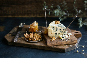 Wall Mural - Danish blue cheese on a wooden board with walnut kernels. Copy space