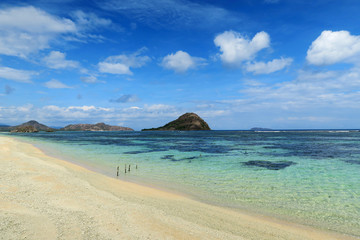 Wall Mural - Beautiful white sand tropical beach with turquoise water and small mountains on horizon