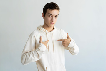 Wall Mural - Serious teen boy pointing at himself. Young man looking at camera. Self-reliance concept. Isolated front view on white background.