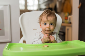 cute baby boy eats biscuits and looking at camera