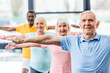 © LIGHTFIELD STUDIOS - selective focus of multicultural senior athletes synchronous doing exercise at gym