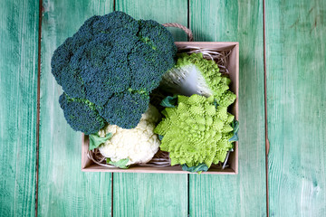 Wall Mural - View of organic broccoli and cauliflower in the box on the kitchen table. Seasonal harvest crop local produce concept. Flat lay. Top view