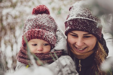 Canvas Print - Funny little child girl wearing in red hat, a scarf, and a warm winter suit with. family, children, christmas, x-mas, love concept - mother and daughter cuddling