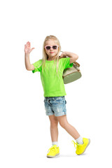 Wall Mural - Full length portrait of cute little kid girl in stylish jeans clothes looking at camera and smiling, standing against white studio wall. Kids fashion concept