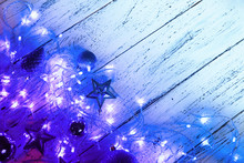 Christmas And New Year Decorations Composition With Stars And Fairy Lights On A Wooden Background. Winter Holydays Backdrop. 