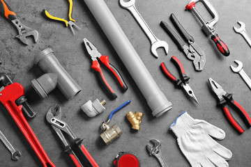 Flat lay composition with plumber's tools on grey background