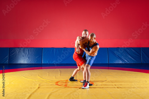 Plakaty Zapasy  dwoch-silnych-zapasnikow-w-niebieskich-i-czerwonych-rajstopach-zapasniczych-zmaga-sie-i-robi-suplex-wrestling
