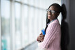© F8  \ Suport Ukraine - Young beauty afro american girl student in glasses holding notebooks in modern University hall