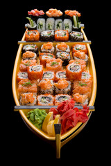 Wall Mural - Sushi set in a wooden boat on a black background