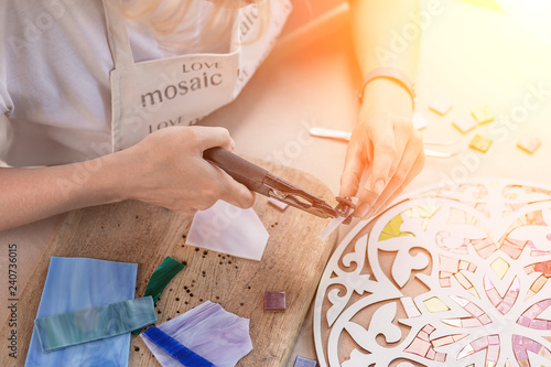 Fotografia, Obraz Hands of master working on new modern colorful mosaic. Close-up