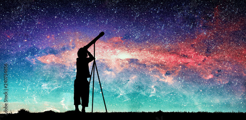 Fotografía Silhouette of little child looking through a telescope