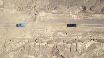 Wall Mural - Two Off-road vehicles on desert road - Aerial footage