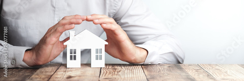 Fotomural Protecting Hands Over House - Home Security And Protection Concept