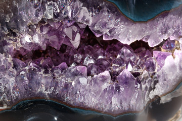 macro mineral stone amethysts in the rock on a white background