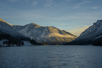 Wall Mural - idyllic sunrise at lake plansee in winter with illuminated alpine mountains