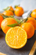 Board with ripe tangerines on table, closeup. Citrus fruit