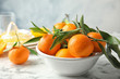 Bowl with ripe tangerines on table. Citrus fruit