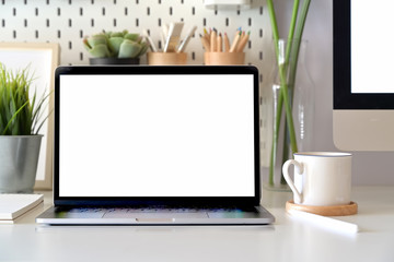 Wall Mural - office desk scenery with mockup blank screen laptop computer. workspace minimal