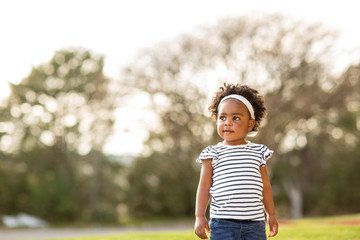 Happy little girl laughing and smiling outside.