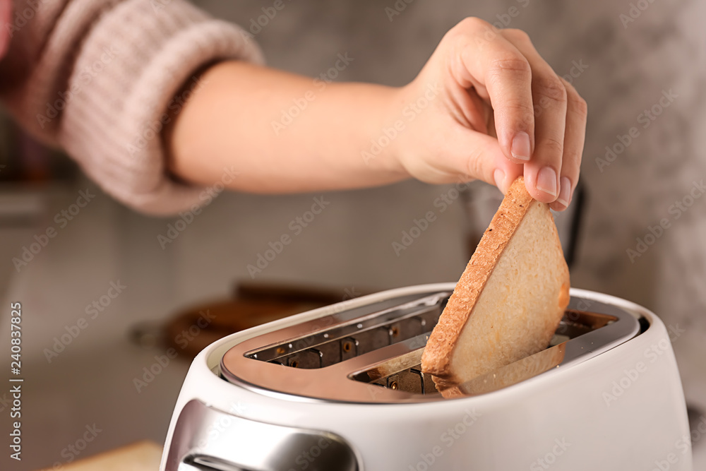 Woman preparing toasts for breakfast in kitchen