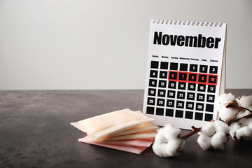 Poster - Calendar with menstrual pads on grey table