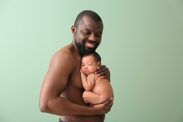 Sticker - Portrait of happy African-American father with little baby on color background